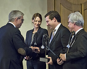 Dekan Matthias Frosch (links) überreicht den Lehrpreis an Katharina Domschke, Marcel Romanos und Jürgen Deckert. (Foto: Patrick Geißler)