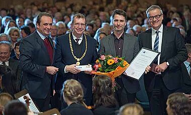 Vergabe des Forschungsförderpreises der Mainfränkischen Wirtschaft (von links): Radu Ferendino von der IHK Würzburg-Schweinfurt, Universitätspräsident Alfred Forchel, Professor Wolfgang Lenhard und Unibund-Vorsitzender David Brandstätter. (Foto: Dan