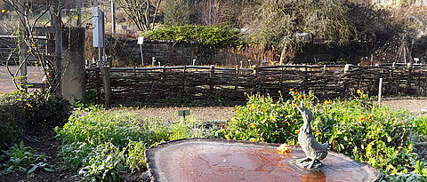 Zugefrorene Wassertränke im Bauerngarten
