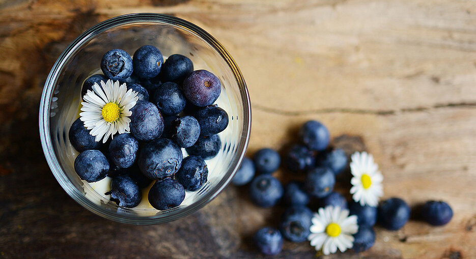 blueberries arranged on a table with daisies