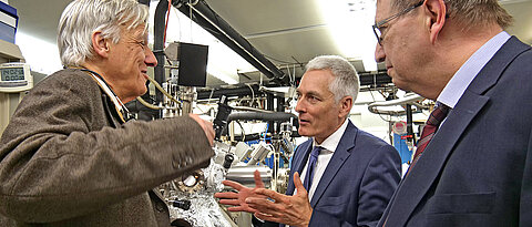 Thomas Gruber (Mitte) im Gespräch im Laurens Molenkamp (l.) in dessen Labor. Rechts: Unipräsident Alfred Forchel.