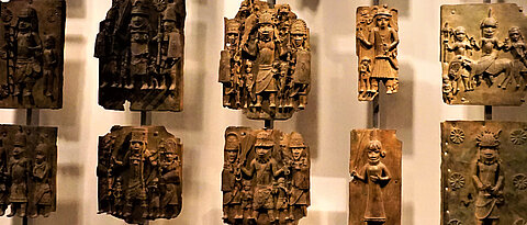 Das Bild zeigt Reliefplatten aus Benin City, ausgestellt im British Museum in London. Die Objekte sind das Thema einer Ausstellung im Universitätszelt auf dem Africa Festival 2022. 