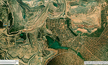 The optical satellite image shows a mine area (left) in Kolwezi, where settlement structures reach right up to the edge of the mine.