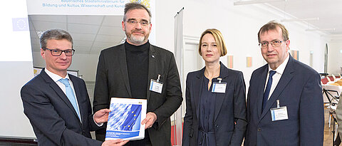 Gruppenfoto mit Staatssekretär Bernd Sibler, Lukas Worschech, Tina Dlugi und Universitätspräsident Alfred Forchel. (Foto: Steffen Leiprecht / STMBW)