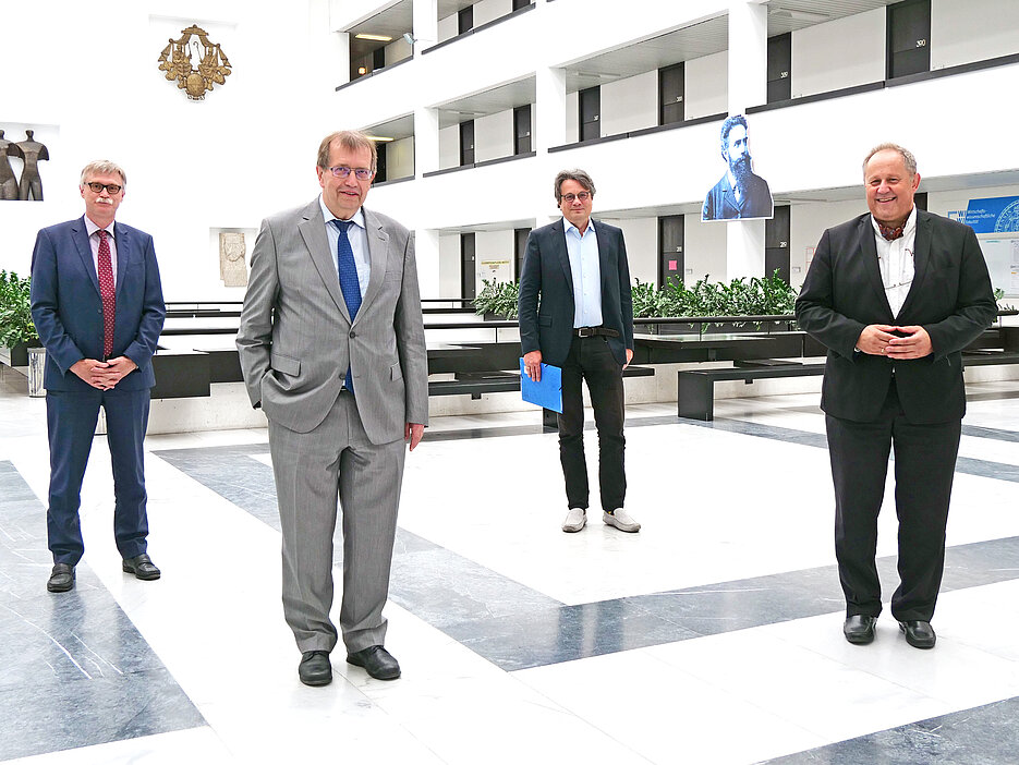 LGL-Stiftungsprofessur1: Gruppenfoto nach der Vertragsunterzeichnung mit dem gehörigen Sicherheitsabstand mit (v.l.): Dr. Uwe Klug, Kanzler, der JMU, Unipräsident Prof. Dr. Alfred Forchel, Prof. Dr. Peter Heuschmann, Vorstand des IKE-B, und Prof. Dr. Manfred Wildner, Leiter des Landesinstituts für Gesundheit am LGL. (Foto: Gunnar Bartsch / Universität Würzburg)