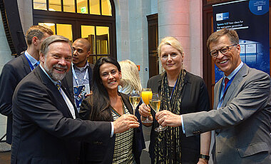 Auf die künftige modulare adaptive Produktion im Weltraum stoßen an (von links nach rechts): Professor Klaus Schilling, Gracia Vittadini, Professorin Pascale Ehrenfreund und Johannes von Thadden. (Foto: Zentrum für Telematik).