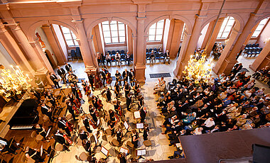 In der vollbesetzen Neubaukirche konnten die Gäste ein hochkarätiges Musikprogramm genießen – unter anderem mit dem Akademischen Orchester der Uni Würzburg.