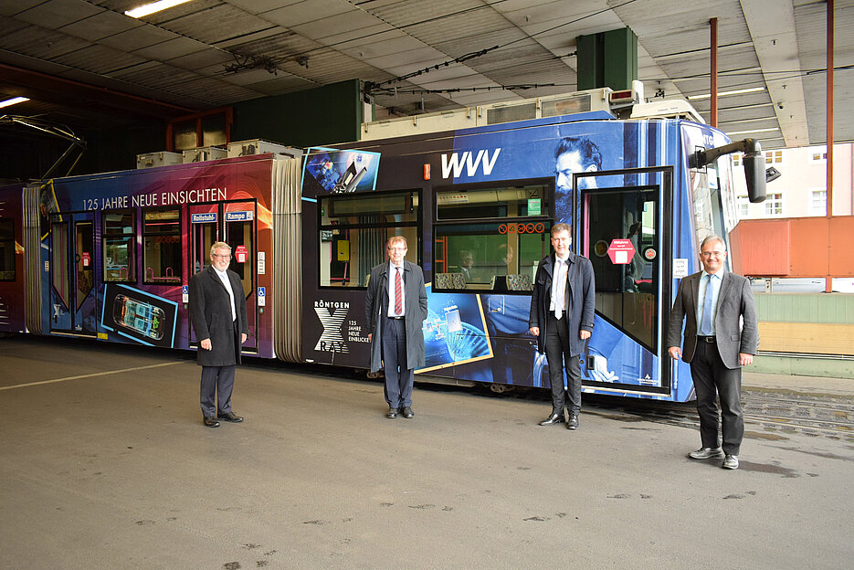 Präsentieren die Röntgen-Straßenbahn (v.l.): WVV-Geschäftsführer Thomas Schäfer, Unipräsident Alfred Forschel, Oberbürgermeister Christian Schuchardt und Bernd Karl, Bereichsleiter Mobilitätsdienstleistungen der WVV. Foto: Pressestelle der JMU 