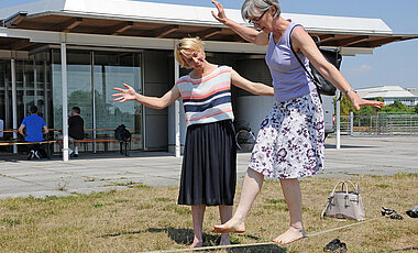 Besucherinnen des Gesundheitstags versuchen sich im Slacklining.