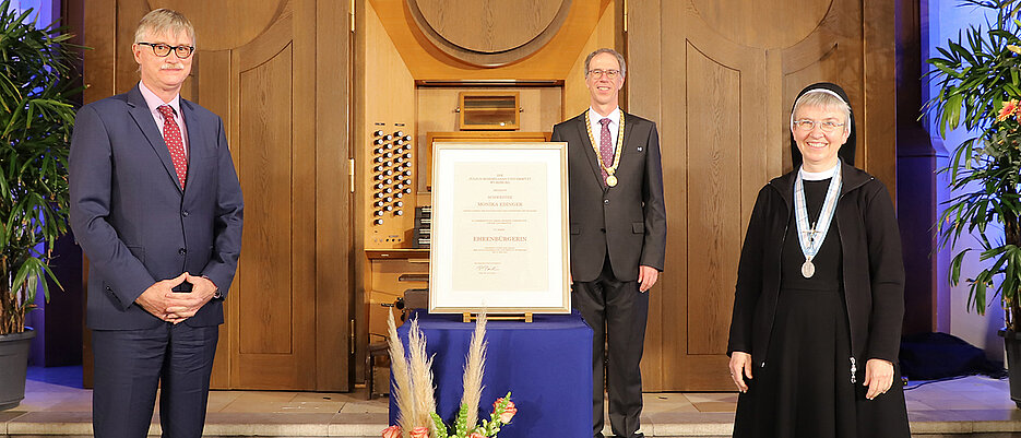 Schwester Maria Monika Edinger bekam die Ehrenbürgerinwürde verliehen. Ihr gratulierten  Laudator und Uni-Kanzler Uwe Klug (l.) sowie Unipräsident Paul Pauli.