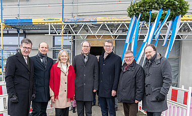 Der Richtkranz wird angehoben im Beisein von (v.l.) Christian Schuchardt, Andreas Hotho, Grit Liebau, Paul Pauli, Markus Blume und den beiden Landtagsabgeordneten Volkmar Halbleib und Patrick Friedl.