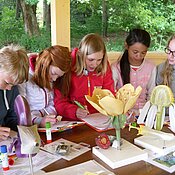 as Foto zeigt Schüler:innen, die am Modell den Aufbau verschiedener Blüten erarbeiten.