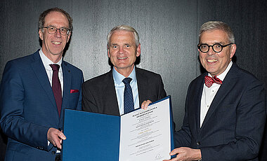 Dirk Heinz (Mitte) bei seiner Ehrenpromotion. Links Würzburgs Universitätspräsident Paul Pauli, rechts Matthias Frosch, Dekan der Medizinischen Fakultät.