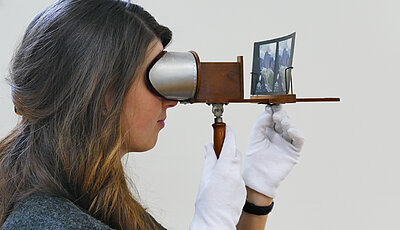 Frau schaut durch ein Stereoskop