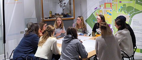 Das Foto zeigt eine Gruppenarbeitsphase mit Studierenden und Dozierenden beim Vernetzungstreffen im Botanischen Garten.