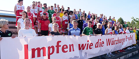 Solch ein Gruppenbild gab es noch nie: Mitglieder mehrerer Würzburger Sportvereine rufen gemeinsam zum Impfen auf. Vorne die Vertreter der Uni, die Professoren Olaf Hoos, wissenschaftlicher Leiter des Sportzentrums (2.v.l.) und Lars Dölken (4.v.l.).