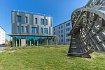 Außenansicht des Neubaus am Campus Hubland Nord mit dem Kunstobjekt „Ennepersche Minimalfläche“ aus der Reihe „Kunst am Bau“.