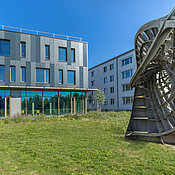 Außenansicht des Neubaus am Campus Hubland Nord mit dem Kunstobjekt „Ennepersche Minimalfläche“ aus der Reihe „Kunst am Bau“.