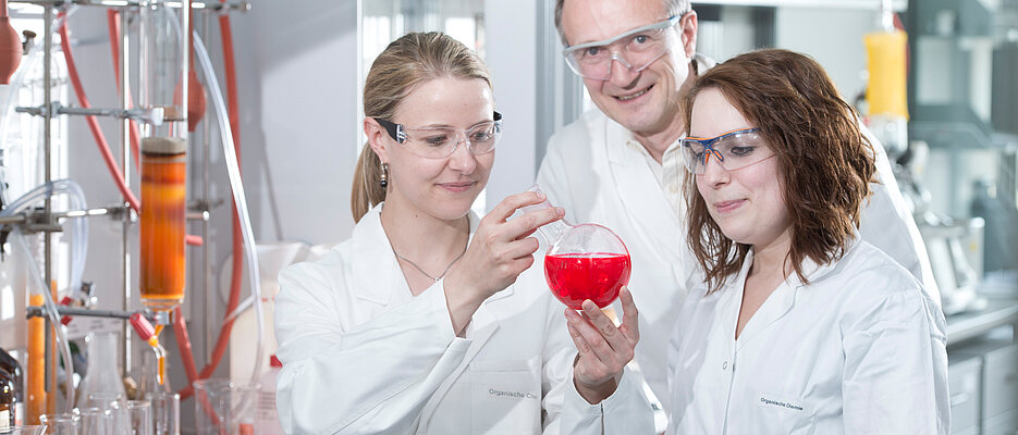 Frank Wuerthner, Professor am Institut fuer Organische Chemie an der Universitaet Wuerzburg, kontrolliert am Montag (19.05.14) mit Doktorandin Stefanie Hoehne (l.) und Masterstudentin Christina Kaufmann im Syntheselabor im Fachbereich Chemie an der Universitaet in Wuerzburg die Entwicklung von Farbstoffen. Die Substanzen, die Wuertner mit seinen Studenten entwickelt, werden unter anderem in der Solartechnik eingesetzt.