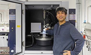 Crystallographer Dr Kazutaka Shoyama in front of his working tool, a single crystal diffractometer. 